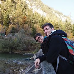 2 junge Männer beugen sich über ein Brückengeländer 